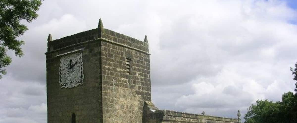 A stone church with a clock tower and an arched entrance.