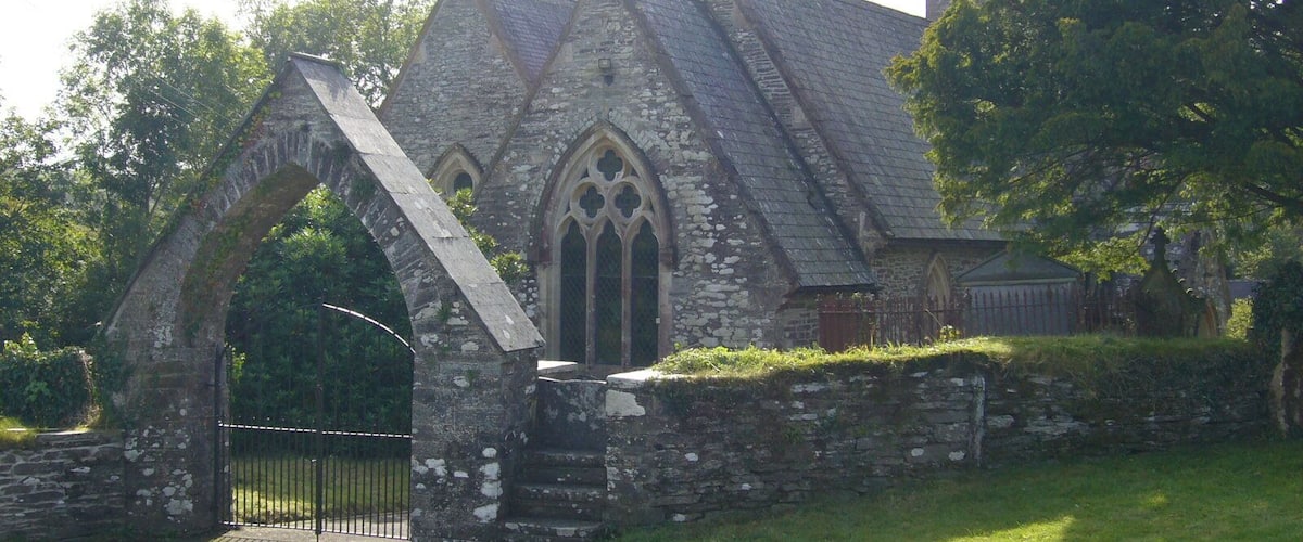 A historic stone church with a pointed archway and crosses on the roof.