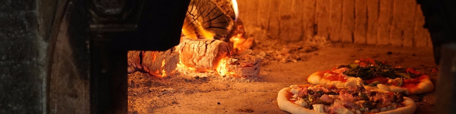 A brick oven with pizzas baking inside.