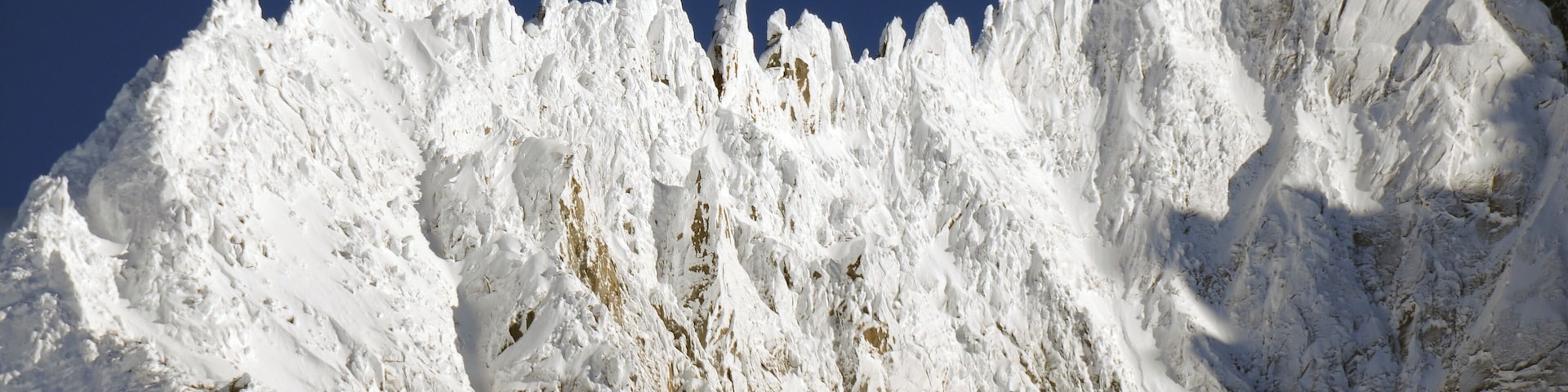 Magnificent mountain chain L'arête des grands Montets with left the hump of Petite Aiguille Verte 3512 m, in the middle the sharp needle of the Pointe de Gigord 3475 m, and right Pointe Farrar 3660 m, just North from Aiguille Carree 3716 m(extreme right rising up); all somewhat North of Aiguille Verte 4122 m, at 21 Januari 2016 with fresh snow! Photo taken from the hotel at 1065 m height and a distance of some 6 km of this ridge.