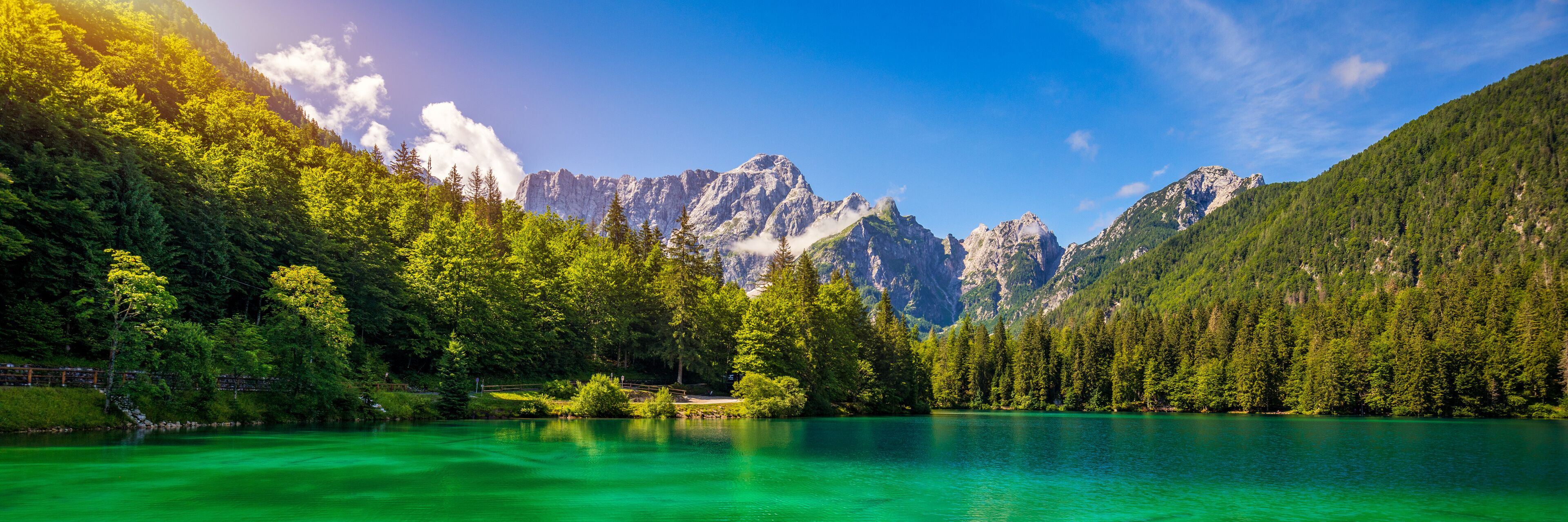 A mountain lake surrounded by dense forests and rugged peaks.