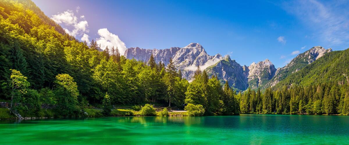 A mountain lake surrounded by dense forests and rugged peaks.