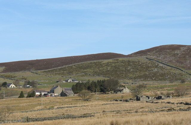 Rolling hills, a rural landscape with houses, and a clear sky.