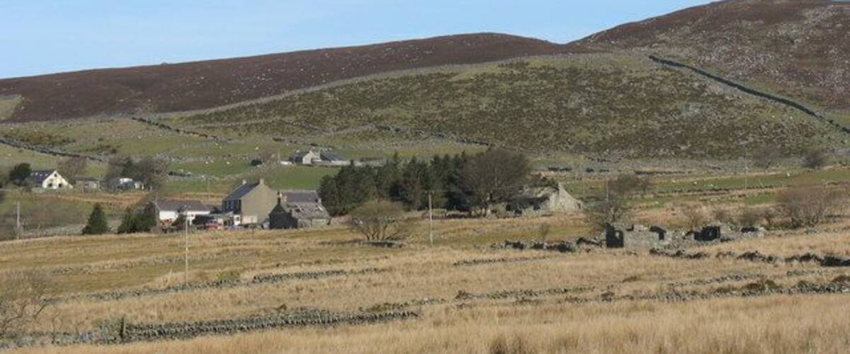 Rolling hills, a rural landscape with houses, and a clear sky.