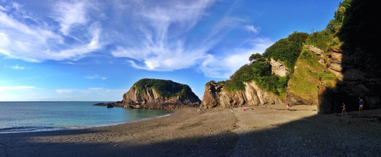 A rocky coastline with cliffs and a beach.