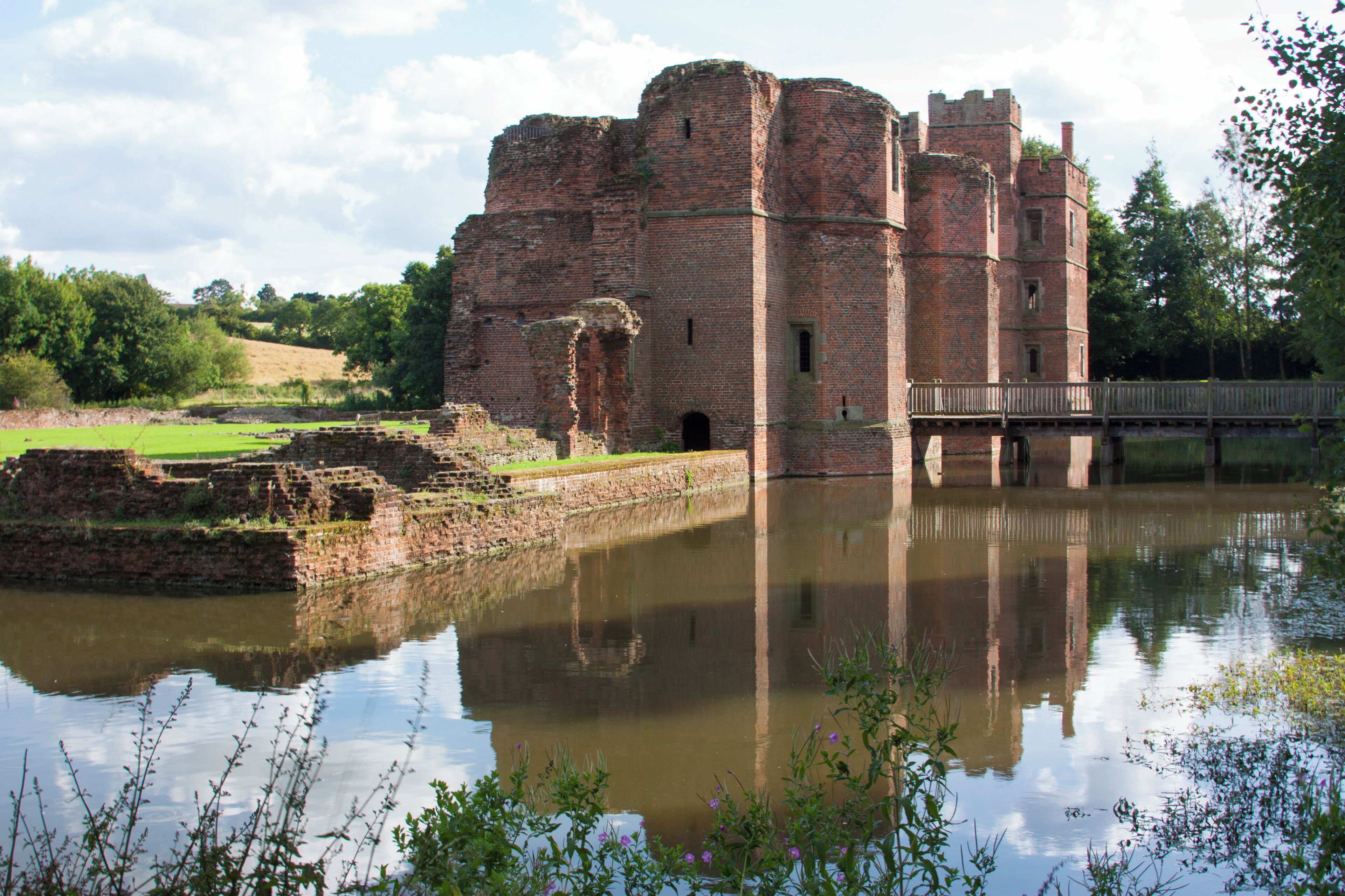 A historic castle with a moat and a wooden bridge.