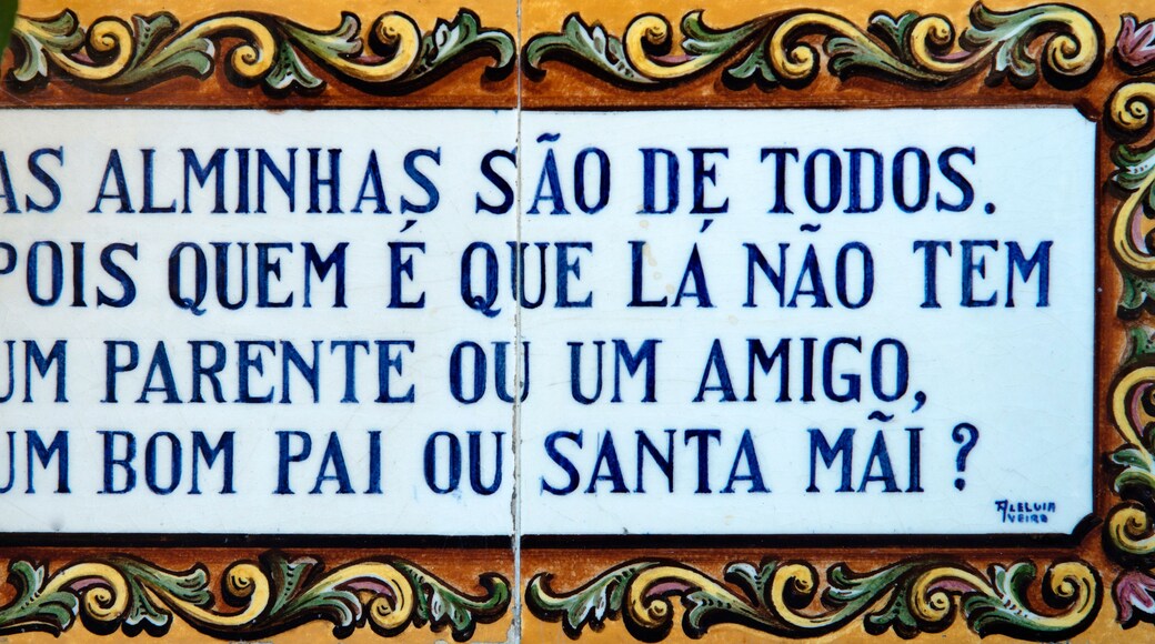 A decorative sign with ornate borders and text in Portuguese.