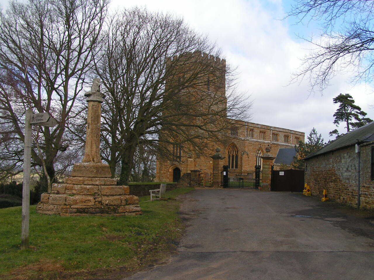 A stone monument, a historic building with arched windows, and a large tower.