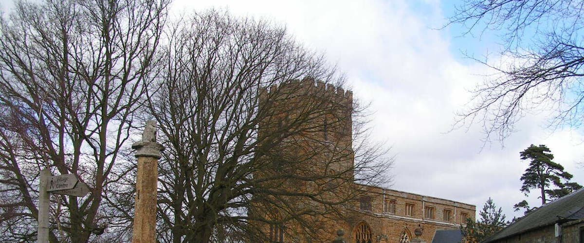 A stone monument, a historic building with arched windows, and a large tower.