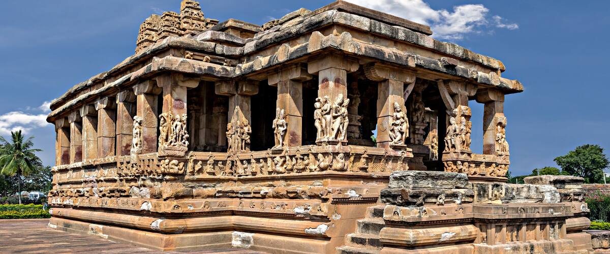 A detailed stone temple with intricate carvings and a clear blue sky.