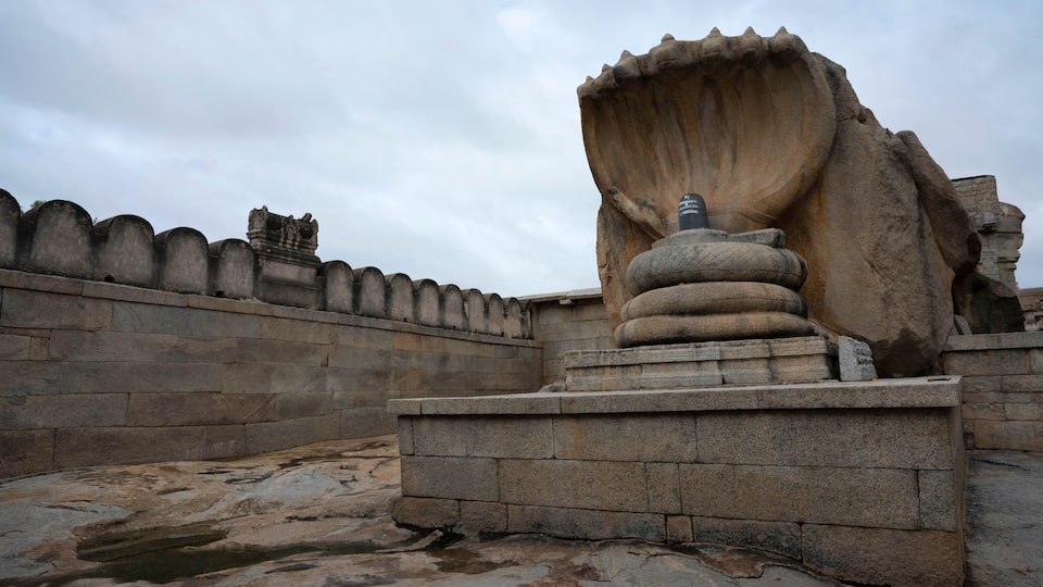 A large stone sculpture with a prominent, curved structure on a stone platform.