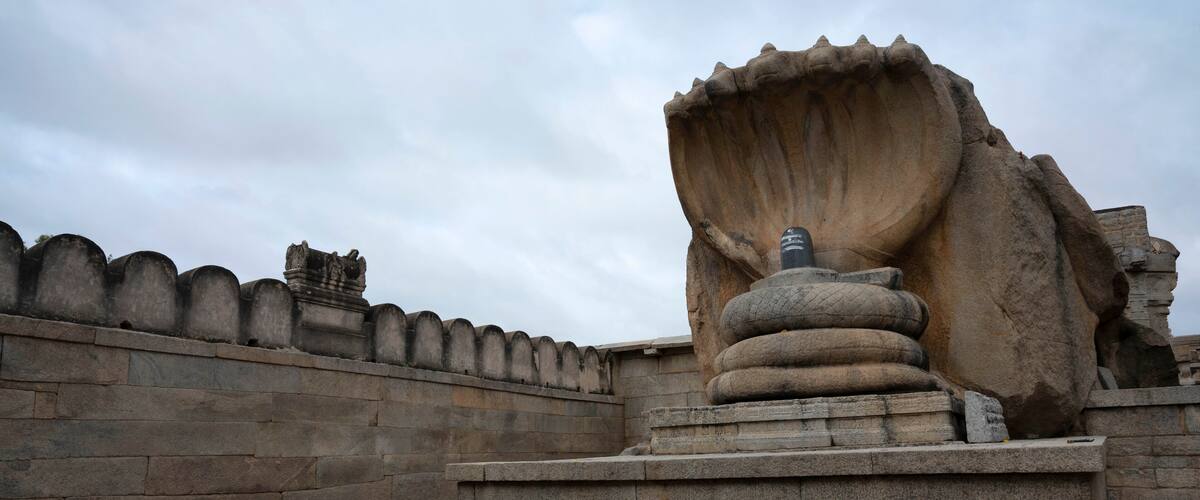 A large stone sculpture with a prominent, curved structure on a stone platform.