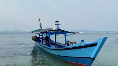 Bandar Lampung, Indonesia - September 1st 2024: Fishing boats are parked on the seashore in the afternoon with a cloudy sky in the background