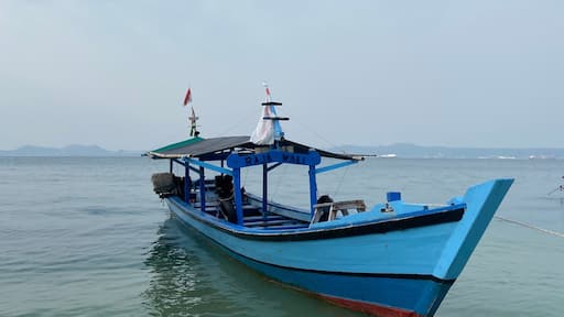 Bandar Lampung, Indonesia - September 1st 2024: Fishing boats are parked on the seashore in the afternoon with a cloudy sky in the background