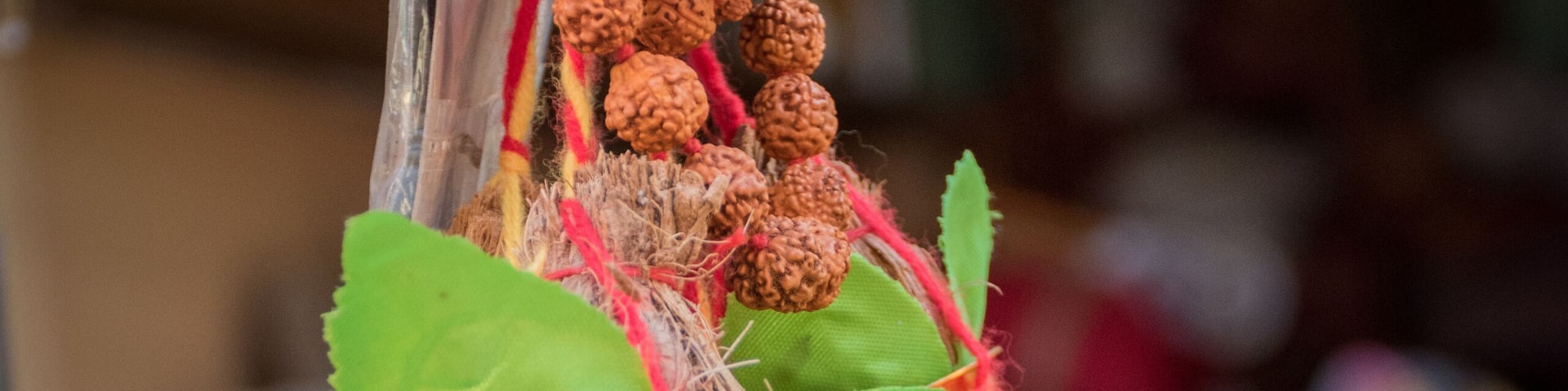 Copper Kalash with rudraksha mala, coconut, mango leaf, red thread or Kalava isolated on blurred background. Essential in Hindu puja. Selective focus.