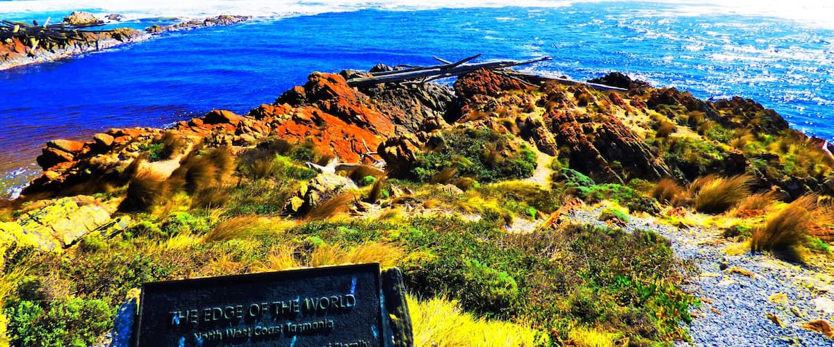 A rocky coastline with a sign reading "The Edge of the World" in West Coast Tasmania.