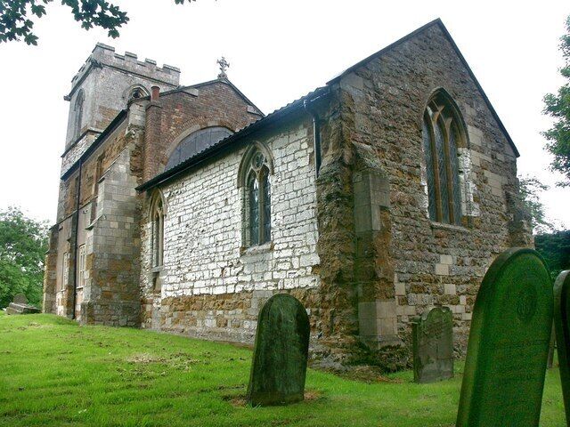 A stone church with a bell tower and two large arched windows.
