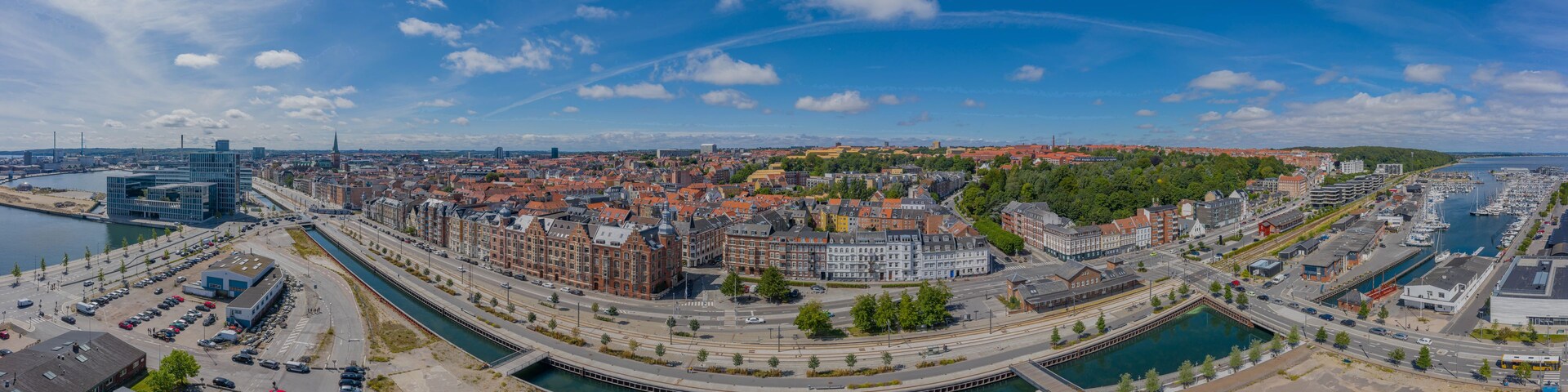 Ein weiter Blick auf eine Stadt mit einem Fluss, historischen Gebäuden und moderner Architektur.