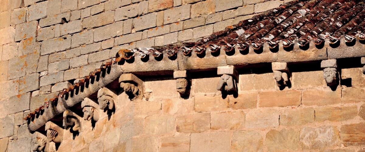 A stone wall with a tiled roof and carved stone figures.