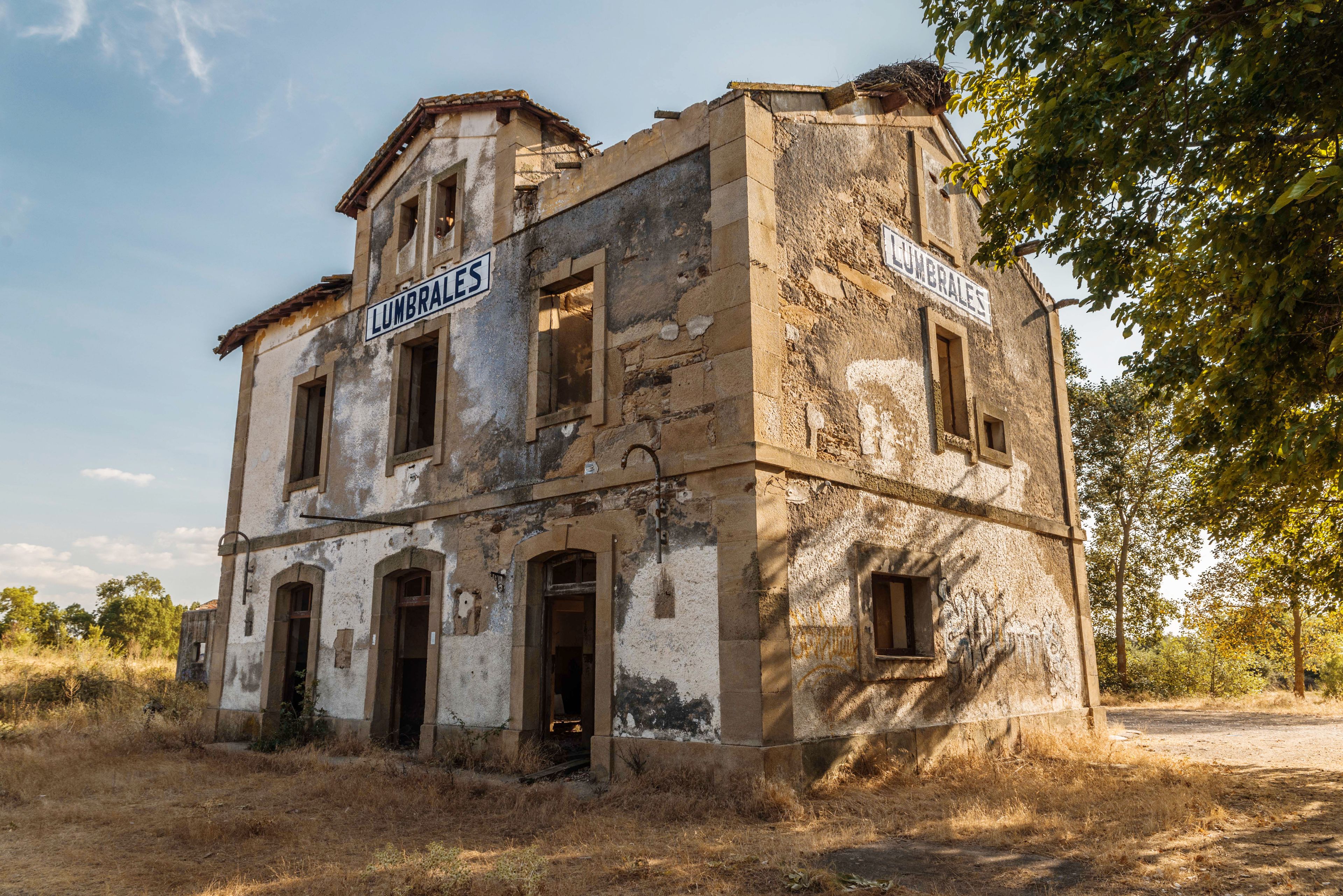 An old, dilapidated building with signs reading 'LUMBRALES' on the facade.