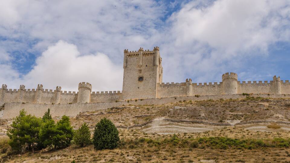 A medieval castle on a hill with a clear sky.