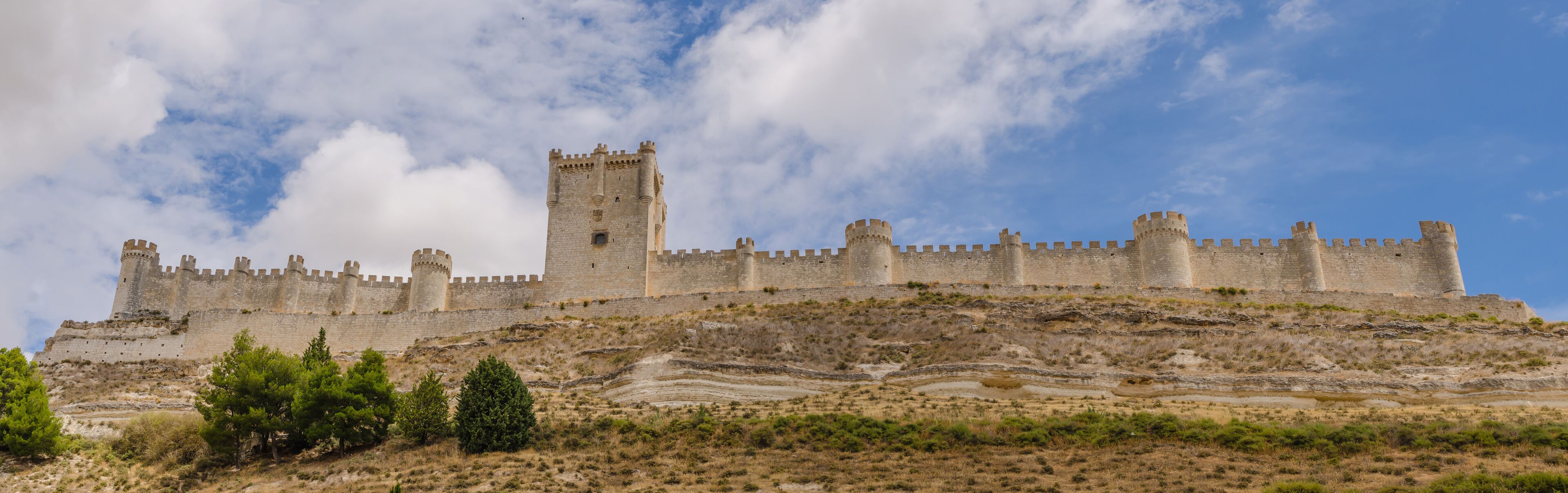 A medieval castle on a hill with a clear sky.