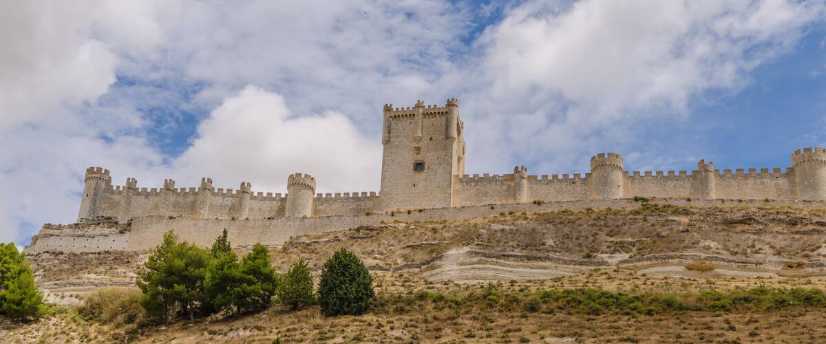 A medieval castle on a hill with a clear sky.