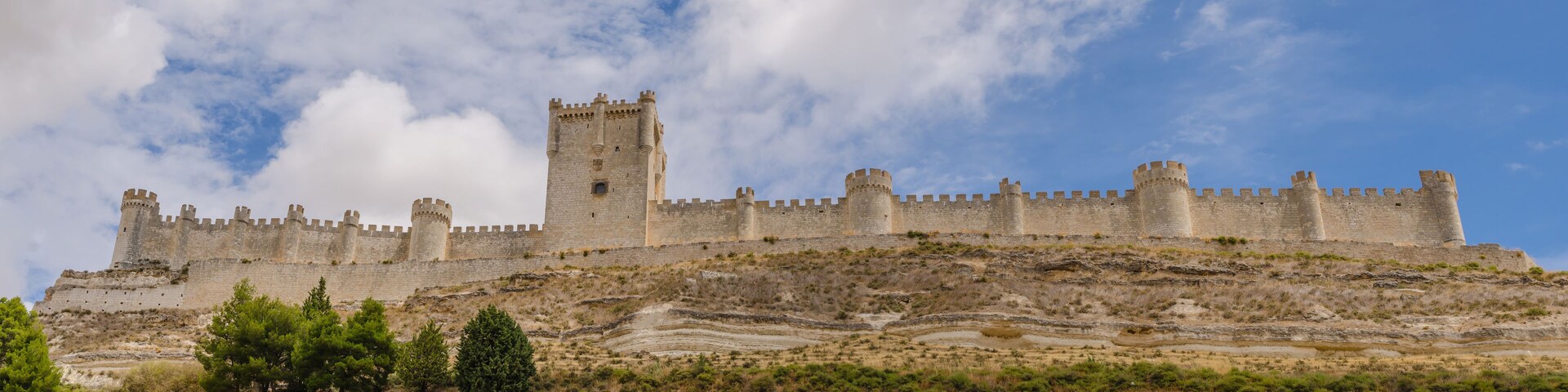 A medieval castle on a hill with a clear sky.