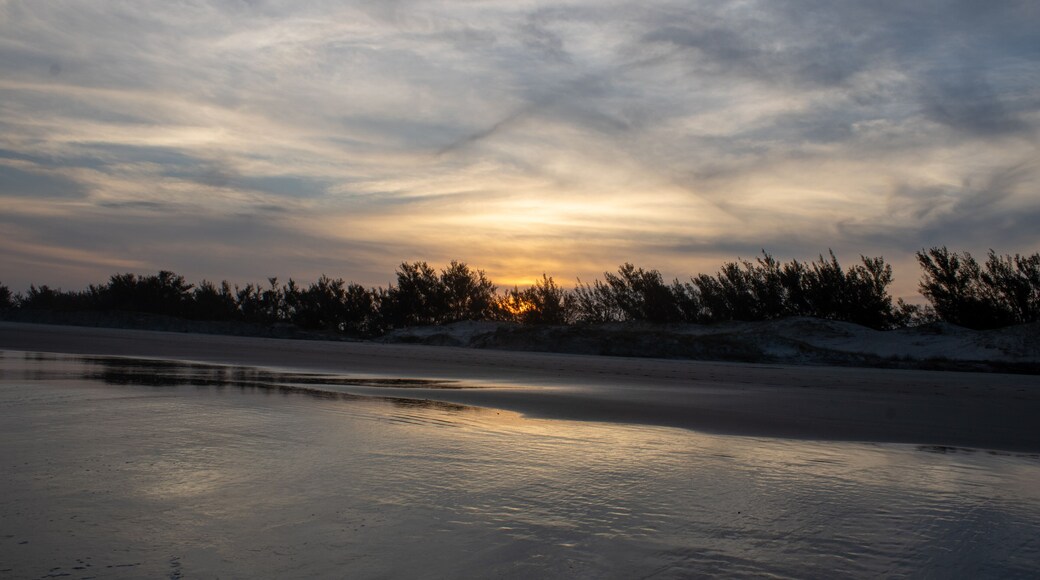 Pôr do sol na praia Village Dunas em Balneário Gaivota, Santa Catarina, Brasil. Capturado durante uma viagem de fim de semana pela praia. Núvens em formato de x.