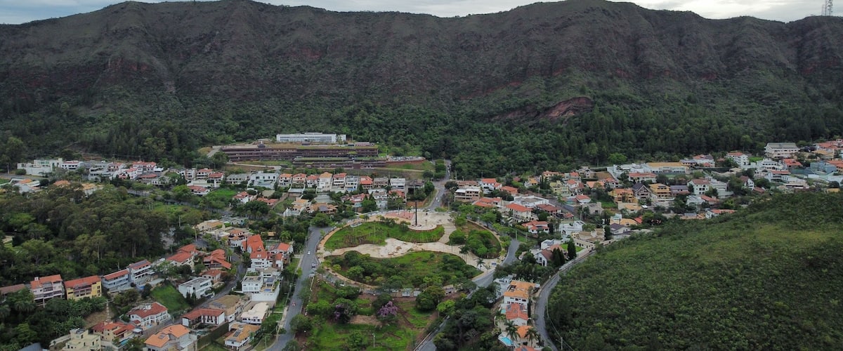 Aerial drone view of Praça do Papa and Serra do Curral in Belo Horizonte, Brazil. The photo shows the square, nearby houses, and the natural park area of Serra do Rola-Moça and Mangabeiras.
