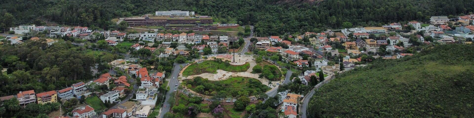Aerial drone view of Praça do Papa and Serra do Curral in Belo Horizonte, Brazil. The photo shows the square, nearby houses, and the natural park area of Serra do Rola-Moça and Mangabeiras.