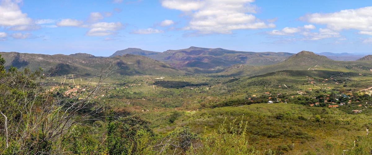 A mountainous landscape with scattered houses and winding roads.