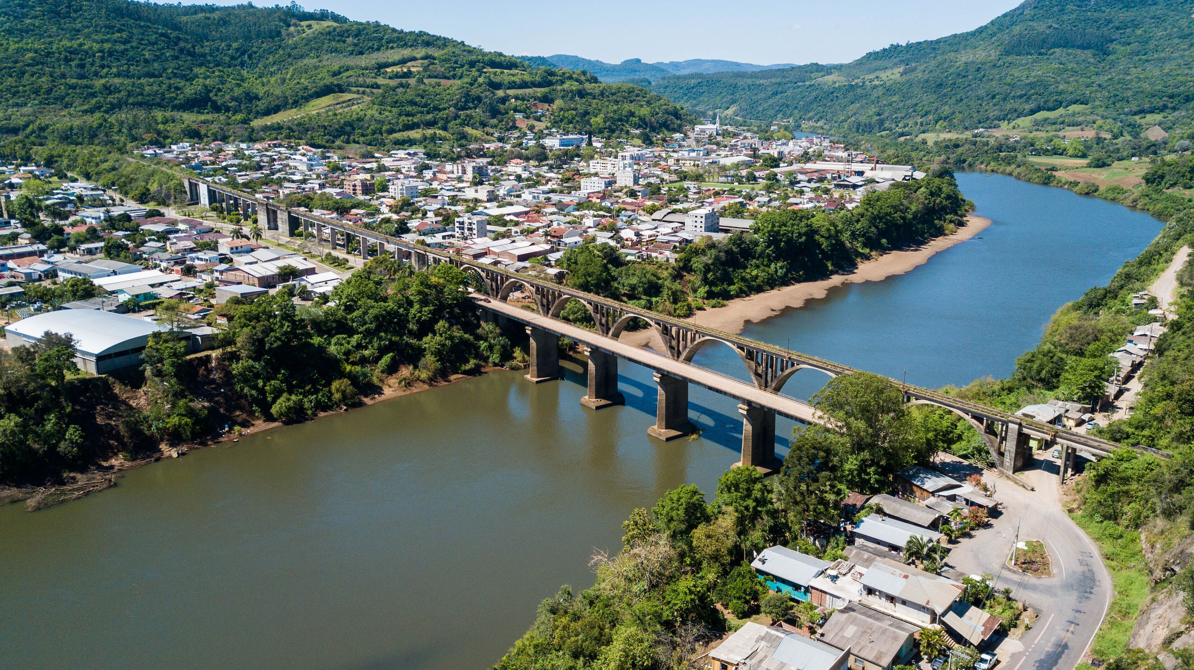 A river flowing through a town with a bridge spanning it.