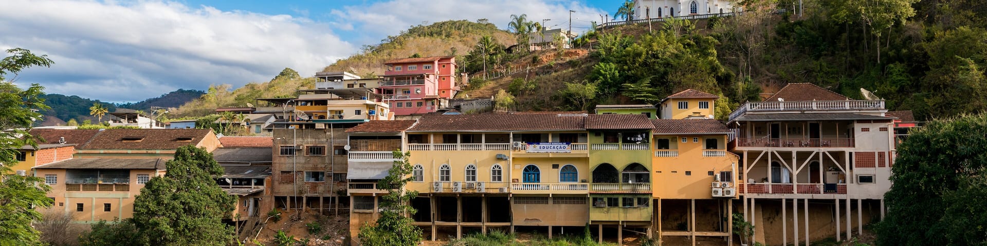 View of Houses in Front of a River and a Church on the Hill in Santa Leopoldina Town in Brazil