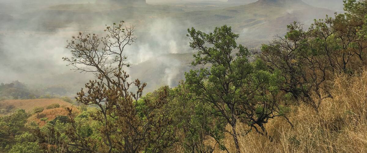 A mountainous landscape with a valley and mist.