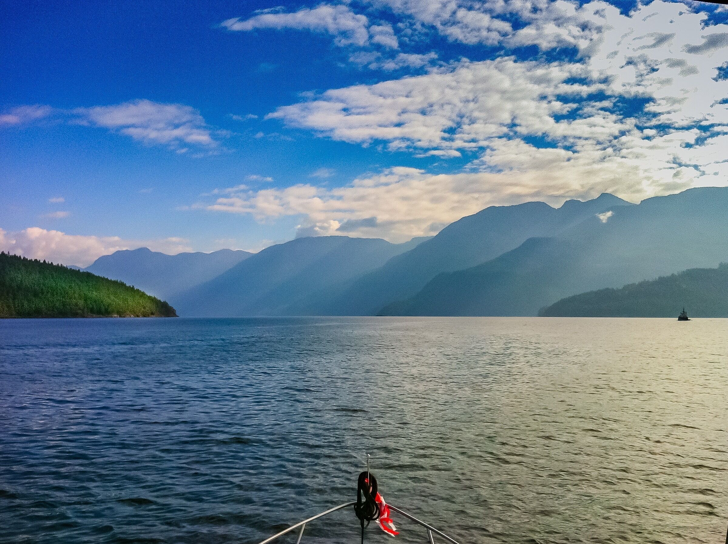 A calm lake with mountains in the background and a boat in the foreground.