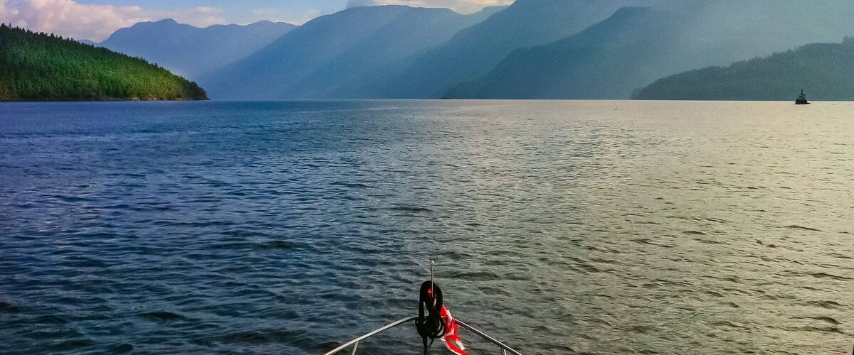 A calm lake with mountains in the background and a boat in the foreground.