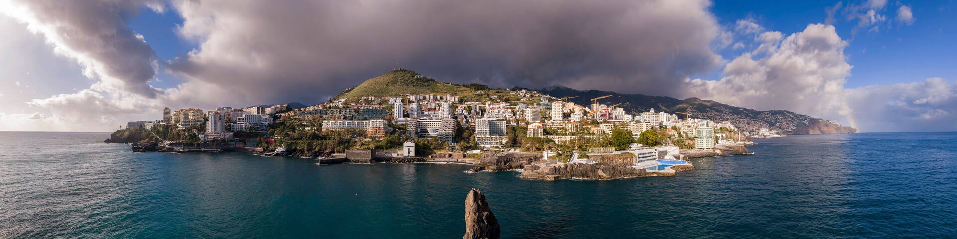 São Martinho coast and ocean pools, São Martinho Funchal Madeira Portugal seaside district with Atlantic waterfront and resort skyline.