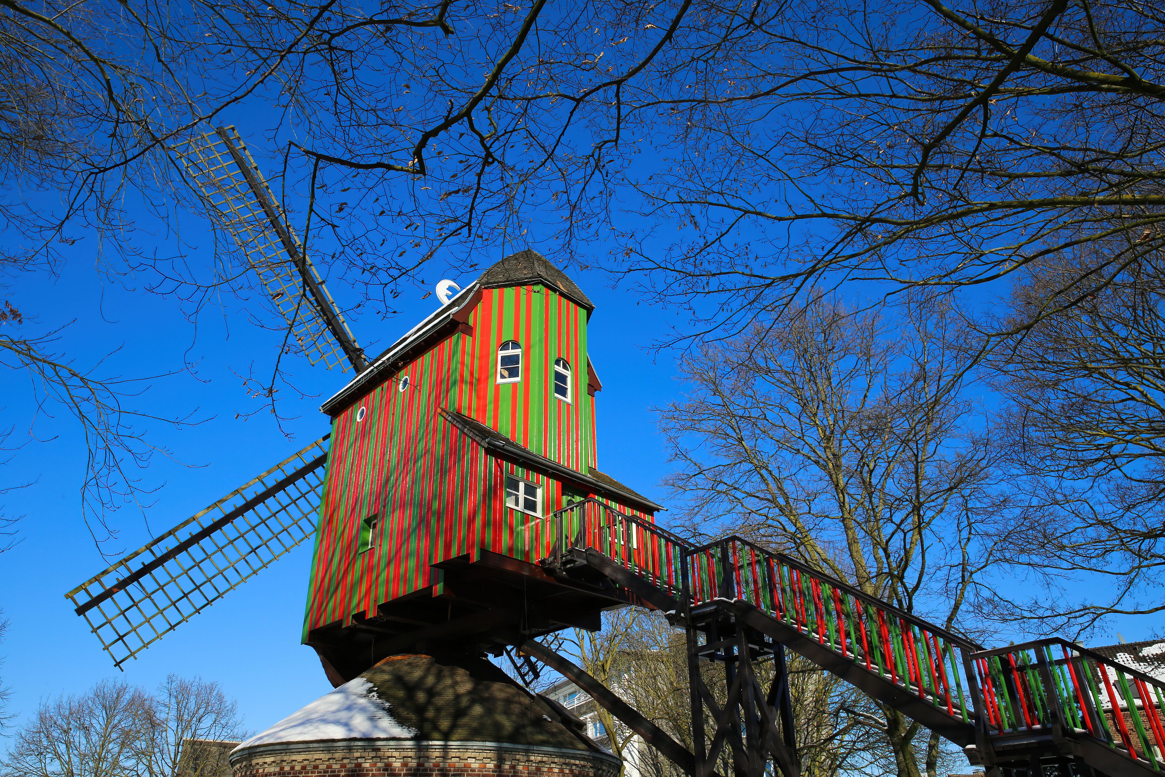 View on red green colorfull striped wind mill (Narrenmuhle) 