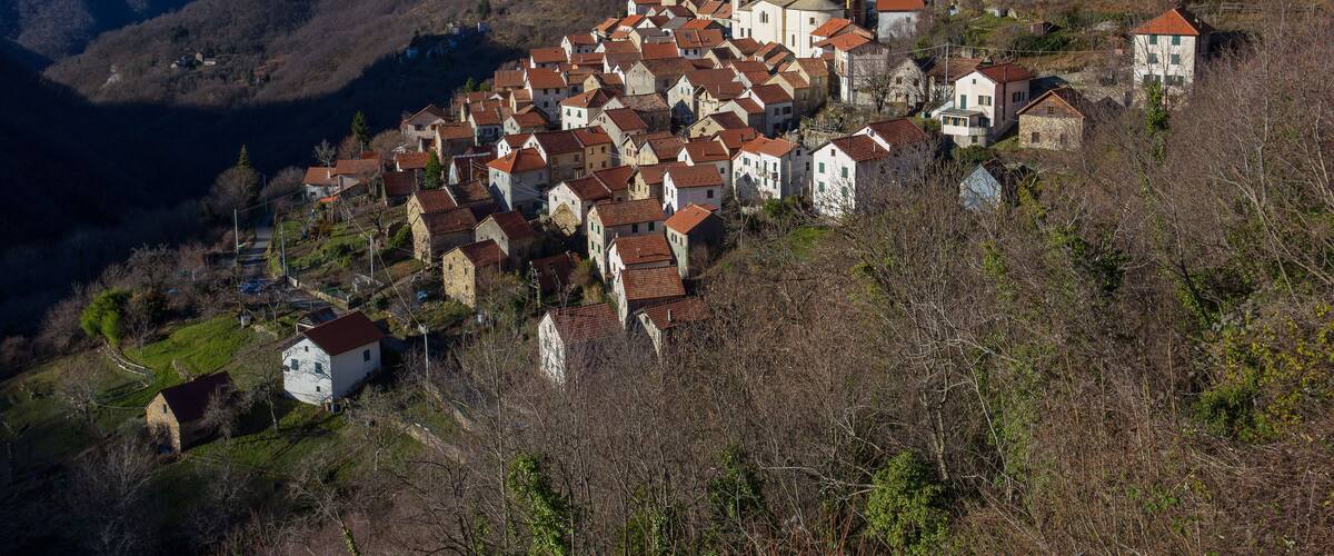 A hillside village with red-roofed houses and a prominent church tower.