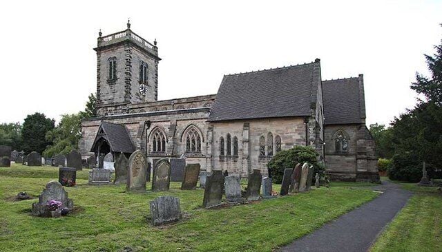 A church with a tower and multiple tombs in the foreground.