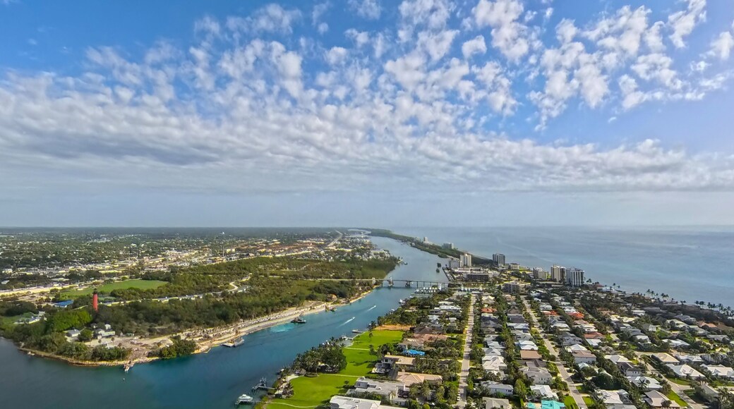 Coastal Heritage: Aerial View of Jupiter Inlet Lighthouse, Waterways, and Atlantic Coastline Under Cloudy Sky, Florida