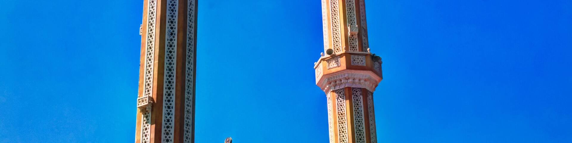 A mosque with two tall minarets and a dome.