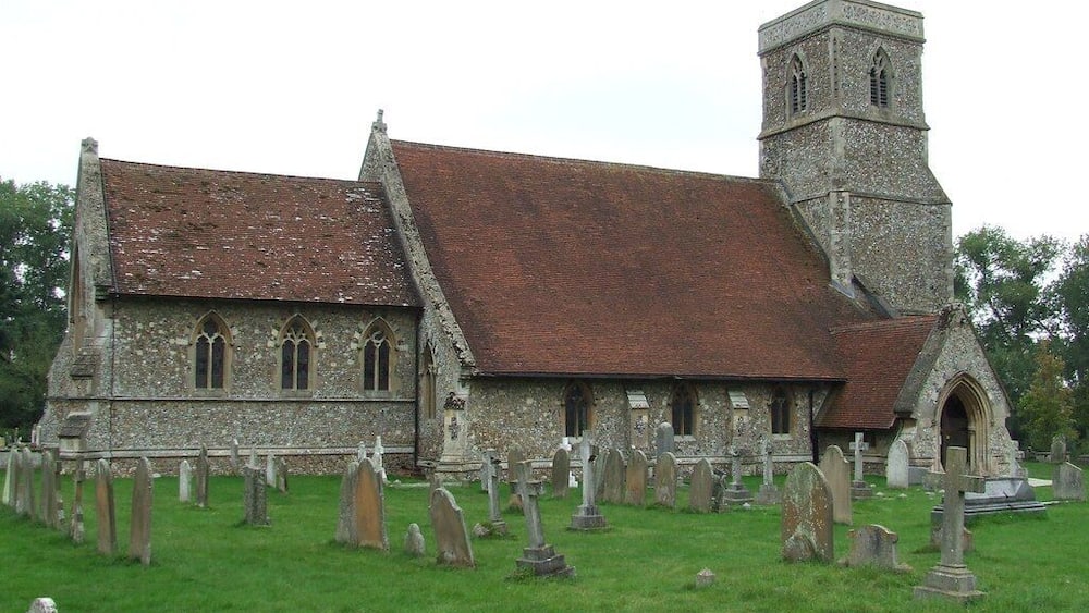 Une église dotée d’un clocher en pierre et d’un cimetière.