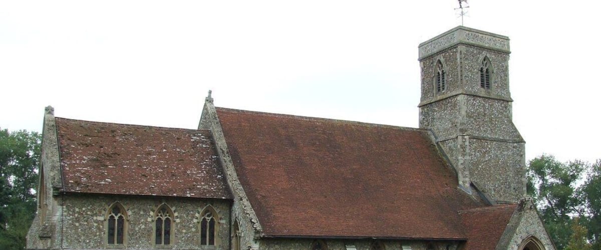 A church with a stone tower and a graveyard.