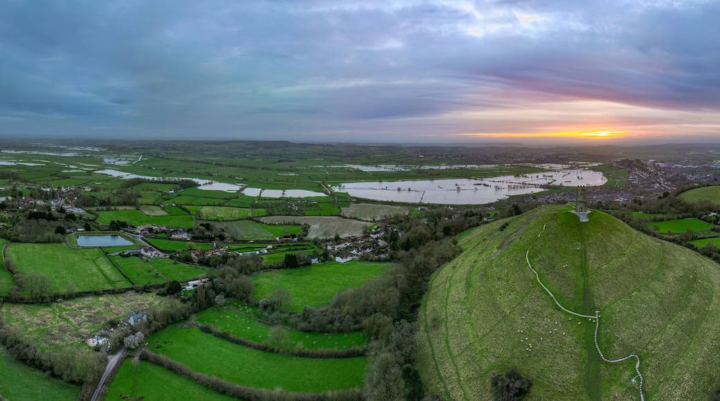 A rural landscape with fields, a winding road, and a distant village.