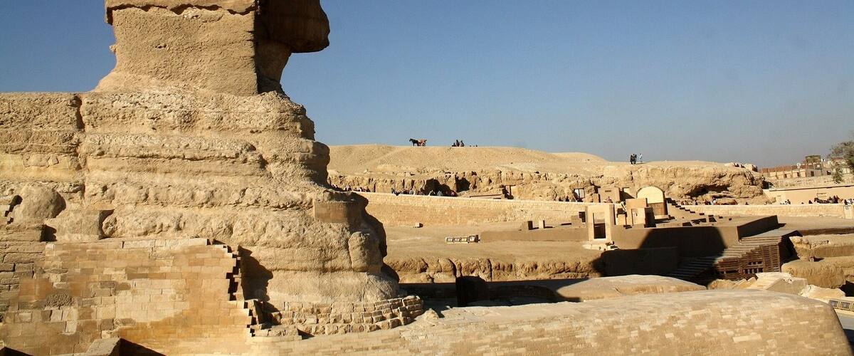 The Great Sphinx of Giza with ancient ruins in the background.