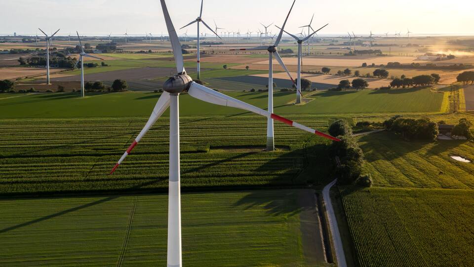 A landscape with multiple wind turbines and agricultural fields.