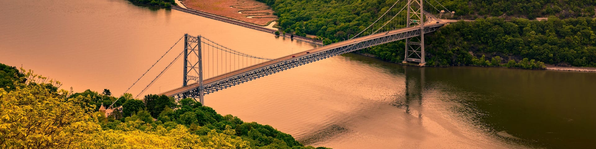 Aerial view of Bear Mountain Bridge at sunrise. Bear Mountain Bridge is a toll suspension bridge in New York State, carrying U.S. Highways 202 and 6 across the Hudson River