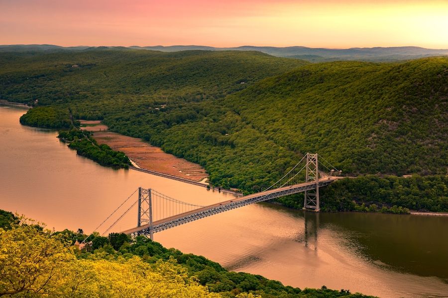 Aerial view of Bear Mountain Bridge at sunrise. Bear Mountain Bridge is a toll suspension bridge in New York State, carrying U.S. Highways 202 and 6 across the Hudson River